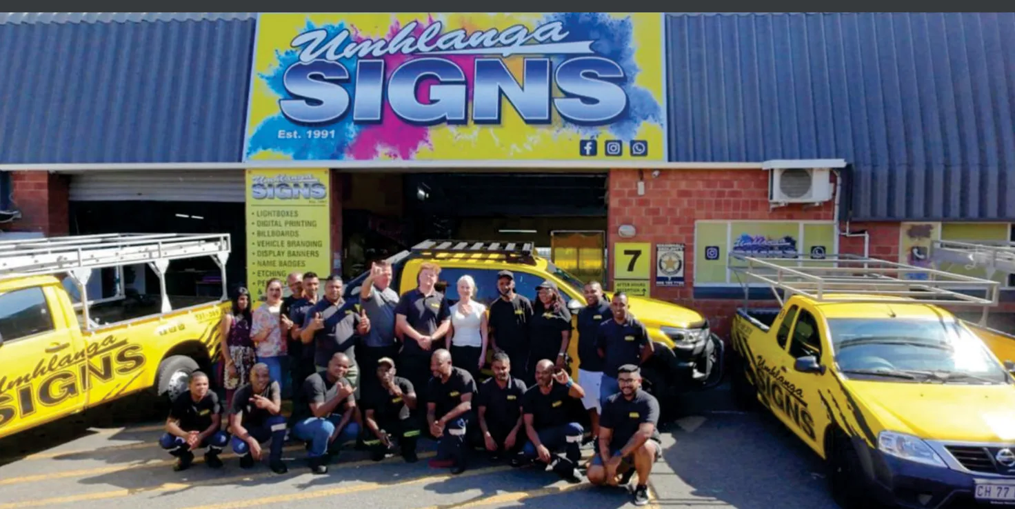 The Umhlanga Signs team outside the Glen Anil premises with branded company vehicles